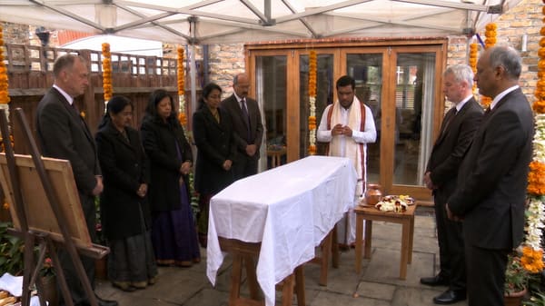 A Hindu funeral service held in a family garden with marigold garlands
